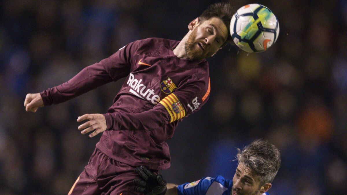 Barcelona's Lionel Messi challenges for the ball with Deportivo's Luisinho during a Spanish La Liga soccer match between Deportivo and Barcelona at the Riazor stadium in A Coruna, Spain.