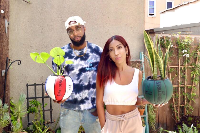 Karissa Allen and Justin Cox holding spalding basketballs with plants inside