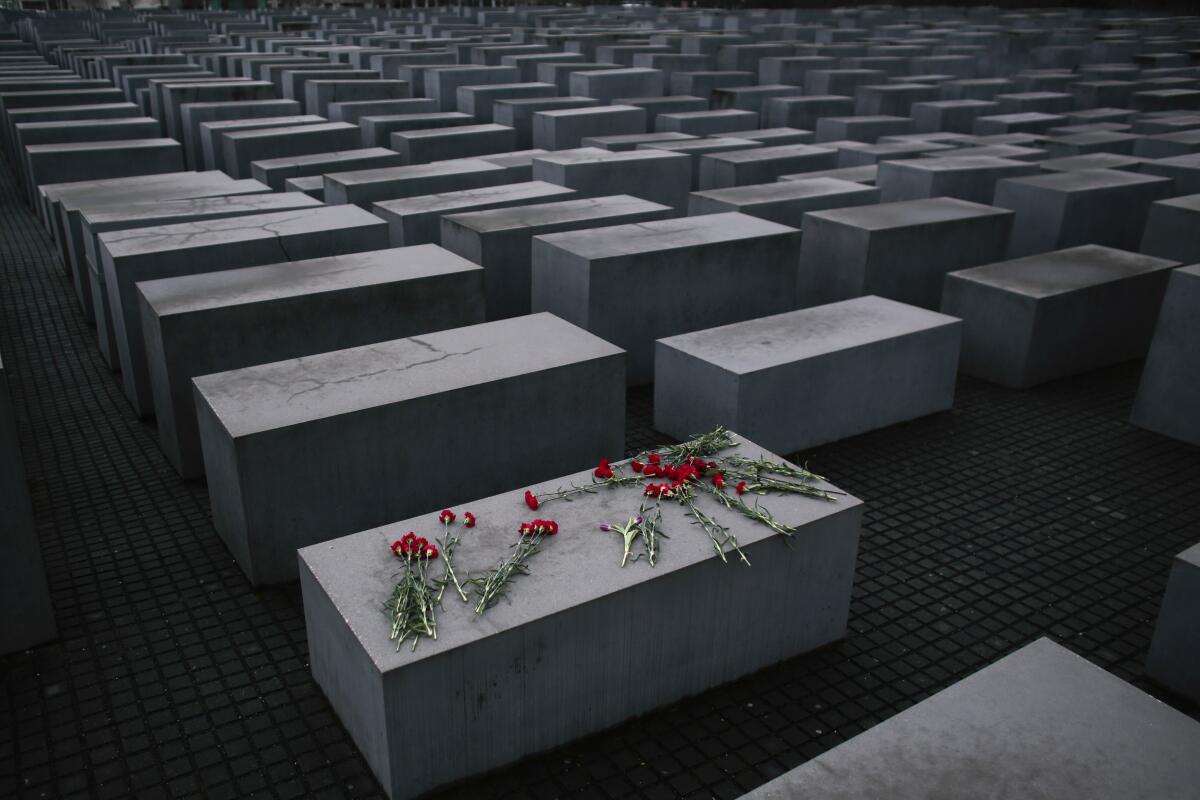 File- Flowers lie on a concrete slab of the Holocaust Memorial to mark the International Holocaust Remembrance Day and commemorating the 70th anniversary of the liberation of the Nazi Auschwitz death camp in Berlin, Jan. 27, 2015. Holocaust survivors from around the world are warning about the reemergence of antisemitism as they commemorated Wednesday, Nov. 9, 2022, the 84th anniversary of the Kristallnacht or the "Night of Broken Glass", when Nazis terrorized Jews throughout Germany and Austria. (AP Photo/Markus Schreiber, File)