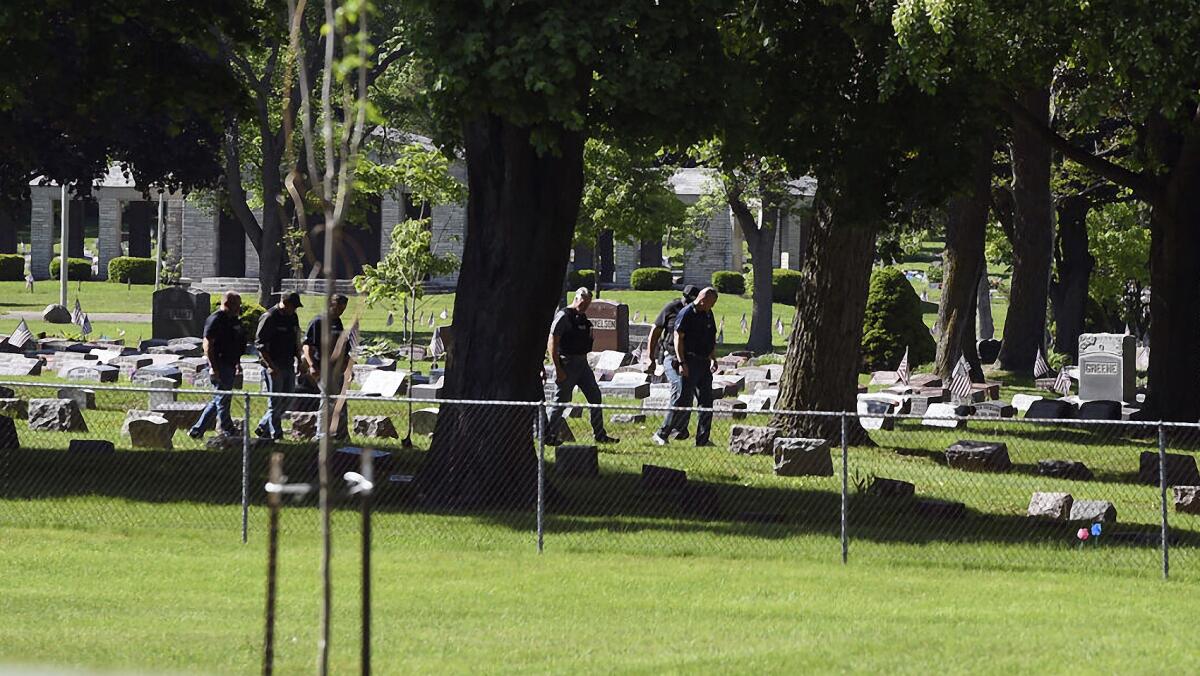 Officers investigate after shots were fired in or near Graceland Cemetery in Racine, Wis., on Thursday, June 2, 2022. Officials say there were multiple victims in the shooting at the cemetery located 30 miles south of Milwaukee. Witnesses said they heard up to 20 to 30 shots. It was not immediately known if there were any fatalities, or if any suspects were in custody.(Alex Rodriguez/The Journal Times via AP)
