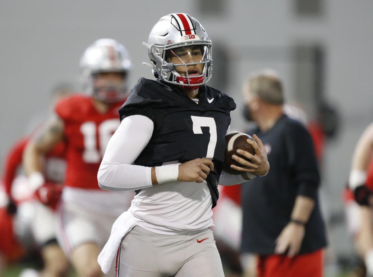 FILE - In this April 5, 2021 file photo, Ohio State quarterback C.J. Stroud runs through a drill during an NCAA college football practice in Columbus, Ohio. Ohio State is one of several national title contenders turning to a new quarterback this season, and C.J. Stroud takes over for the Buckeyes without a single college pass attempt. His debut for the four-time defending Big Ten champions comes on Thursday, Sept. 2 on the road against an experienced Minnesota team. (AP Photo/Paul Vernon, File)
