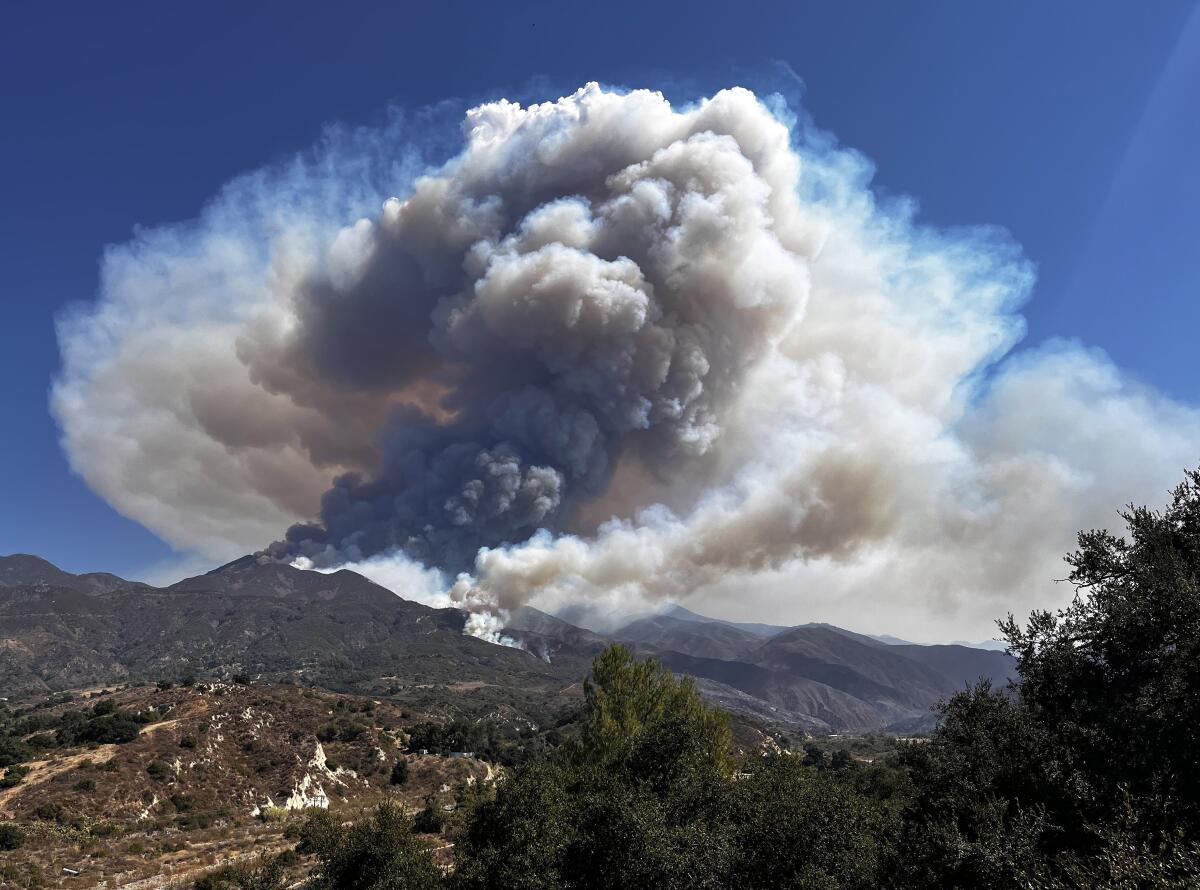 Smoke rises above mountains.