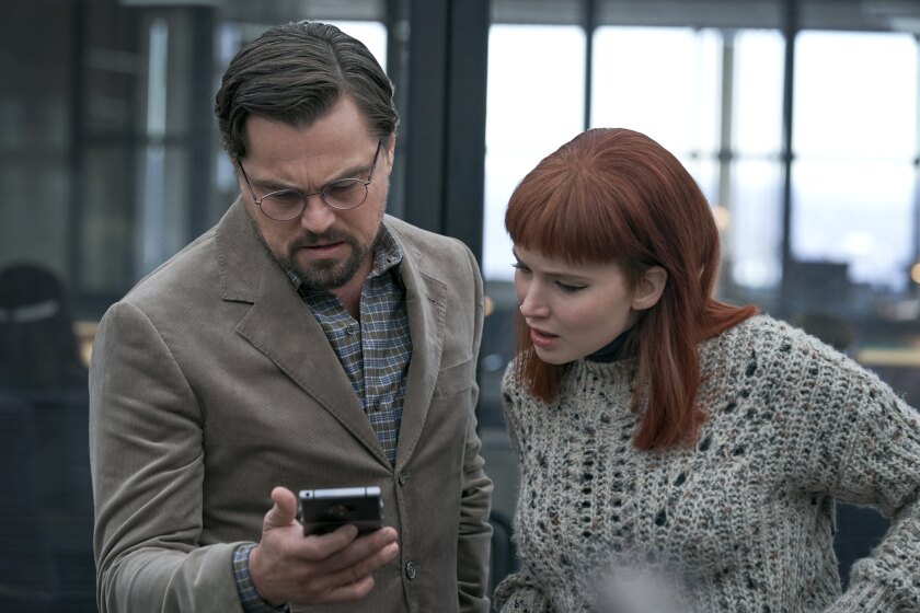 This image released by Netflix shows Leonardo DiCaprio as Dr. Randall Mindy and Jennifer Lawrence as Kate Dibiasky in a scene from "Don't Look Up." (Niko Tavernise/Netflix via AP)