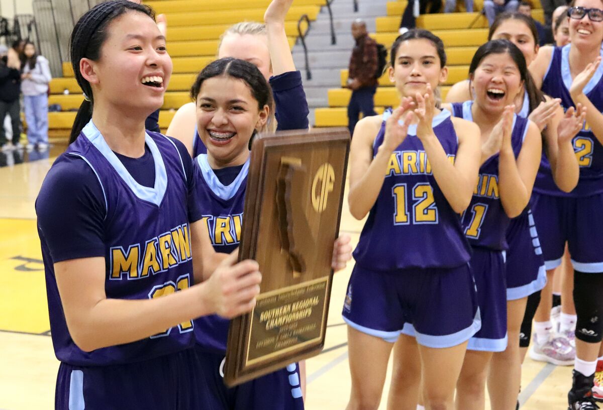 Marina's Tiana To (31) holds the CIF State Southern California Regional Division V plaque as she celebrates with her team.