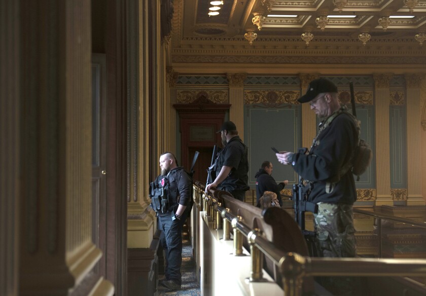 Armed members of a militia group inside the Michigan Capitol in Lansing last April wait for the state Senate to vote.