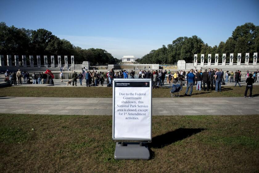 People linger at the World War II Memorial after a rally at the monument on the National Mall in Washington. Activists from several veterans groups gathered to protest the government shutdown and call for resolutions to the budget crisis.