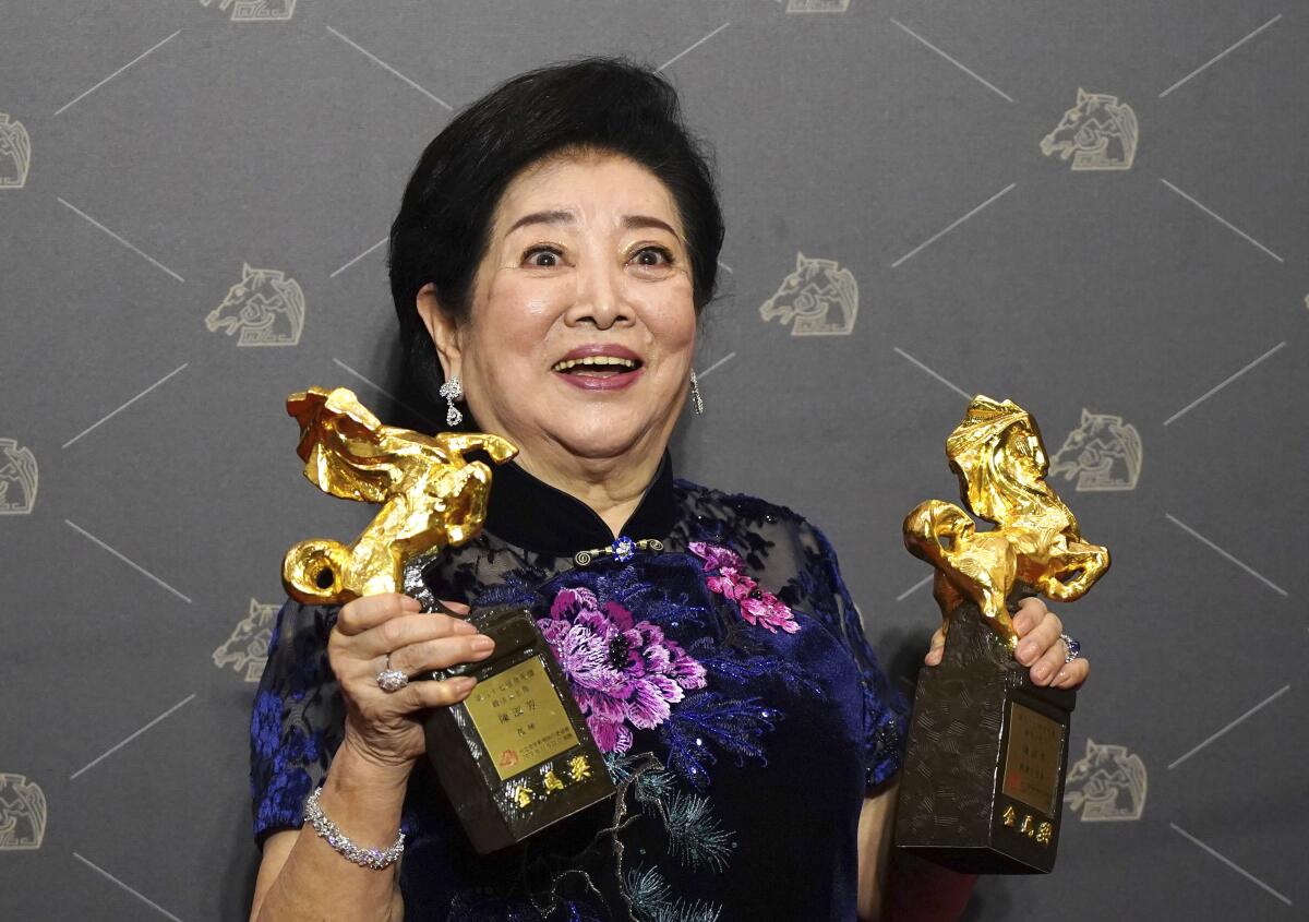 Taiwanese actress Chen Shu-fang holds her awards for leading actress and supporting actress at the 57th Golden Horse Awards