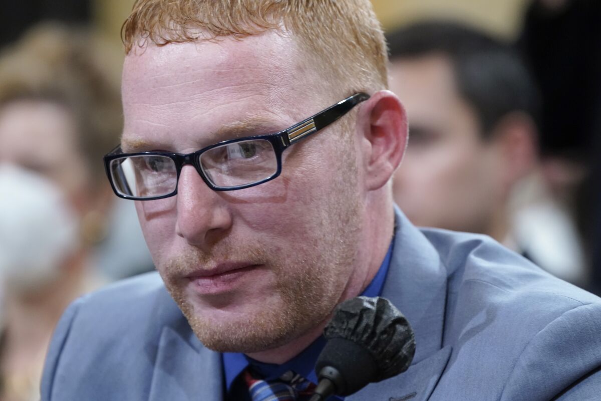 Stephen Ayres sits at a microphone.