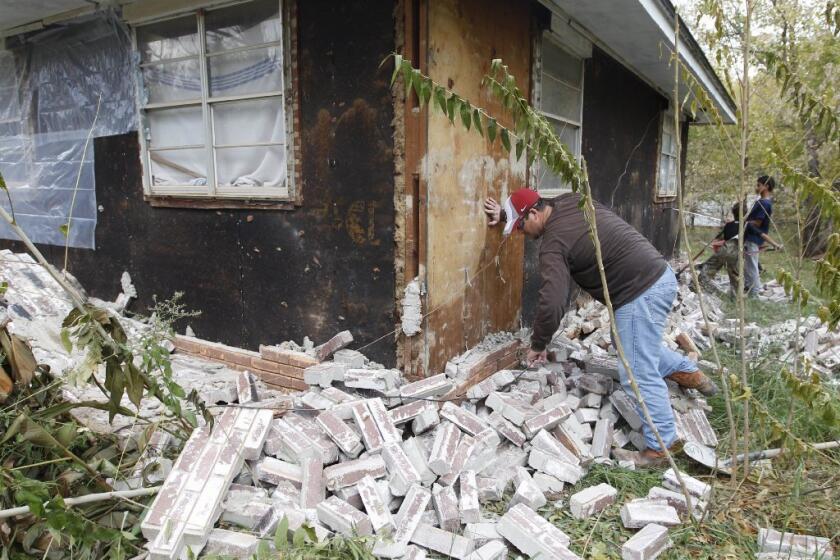 Chad Devereaux of Sparks, Okla., examines damage to his in-laws' home after two earthquakes hit the area in less than 24 hours in 2011.