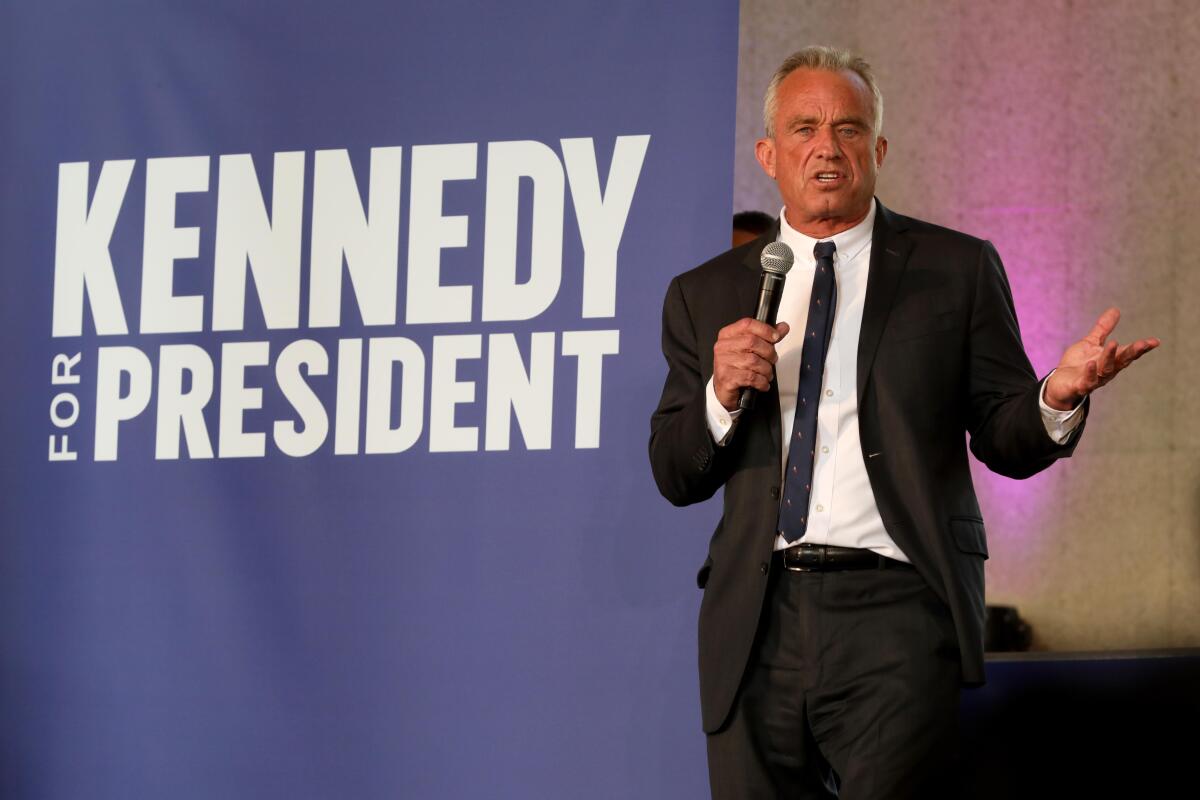Robert F. Kennedy, Jr. speaks next to the words Kennedy for President on a wall.
