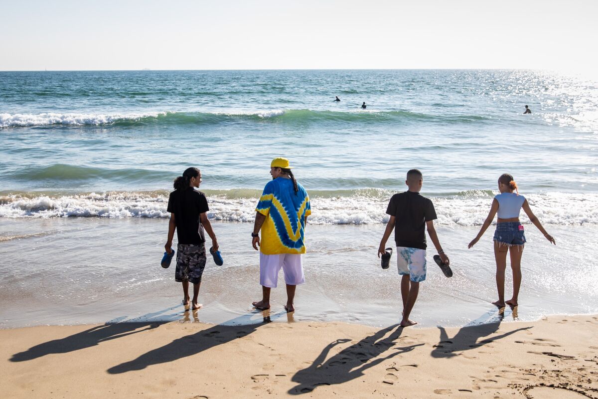 A family walks in the surf at the beach