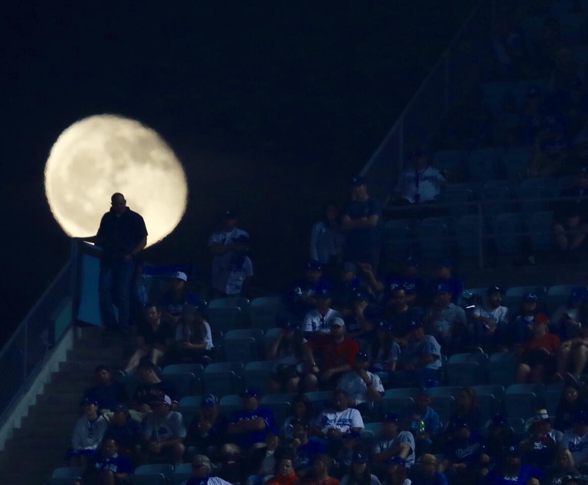 A Dodger fan is silhouetted by the moon during Game 3 of the World Series between the Los Angeles Dodgers and Boston Red Sox.