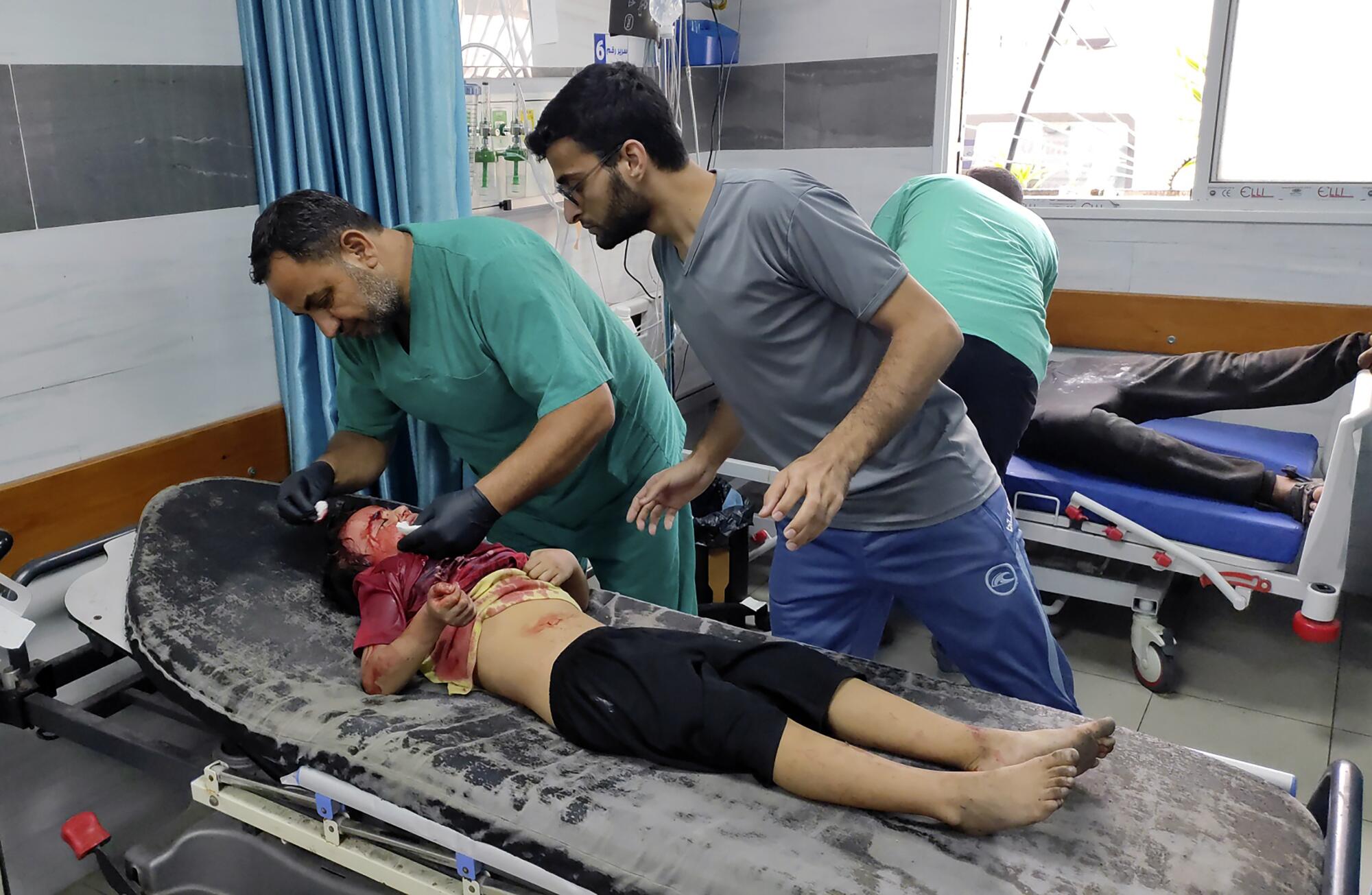 A bloody Palestinian child on a stretcher in Gaza.