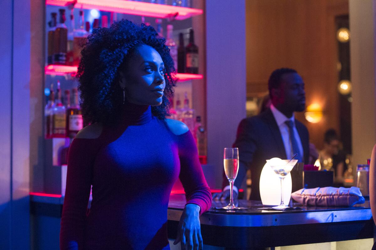 A woman leans on the bar in a nightclub