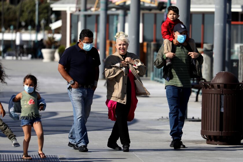 REDONDO BEACH, CA - APRIL 27: People walk along the pier on Tuesday, April 27, 2021 in Redondo Beach, CA. U.S. health officials say fully vaccinated Americans don't need to wear masks outdoors anymore unless they are in a big crowd of strangers (Associated Press). (Gary Coronado / Los Angeles Times)