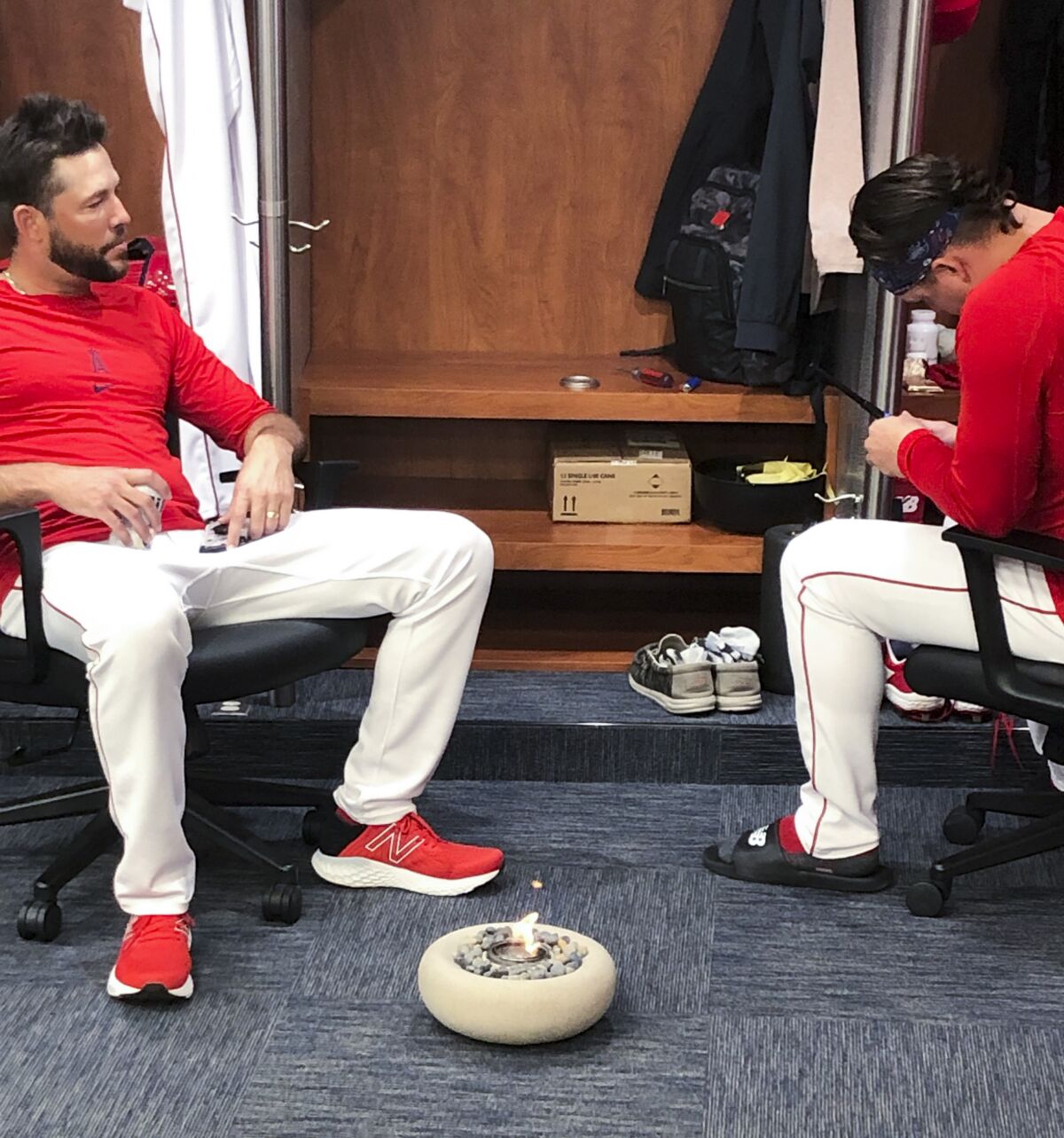 Angels relievers Aaron Loup, right, and Ryan Tepera light up a little fire pit in the clubhouse after a recent win.