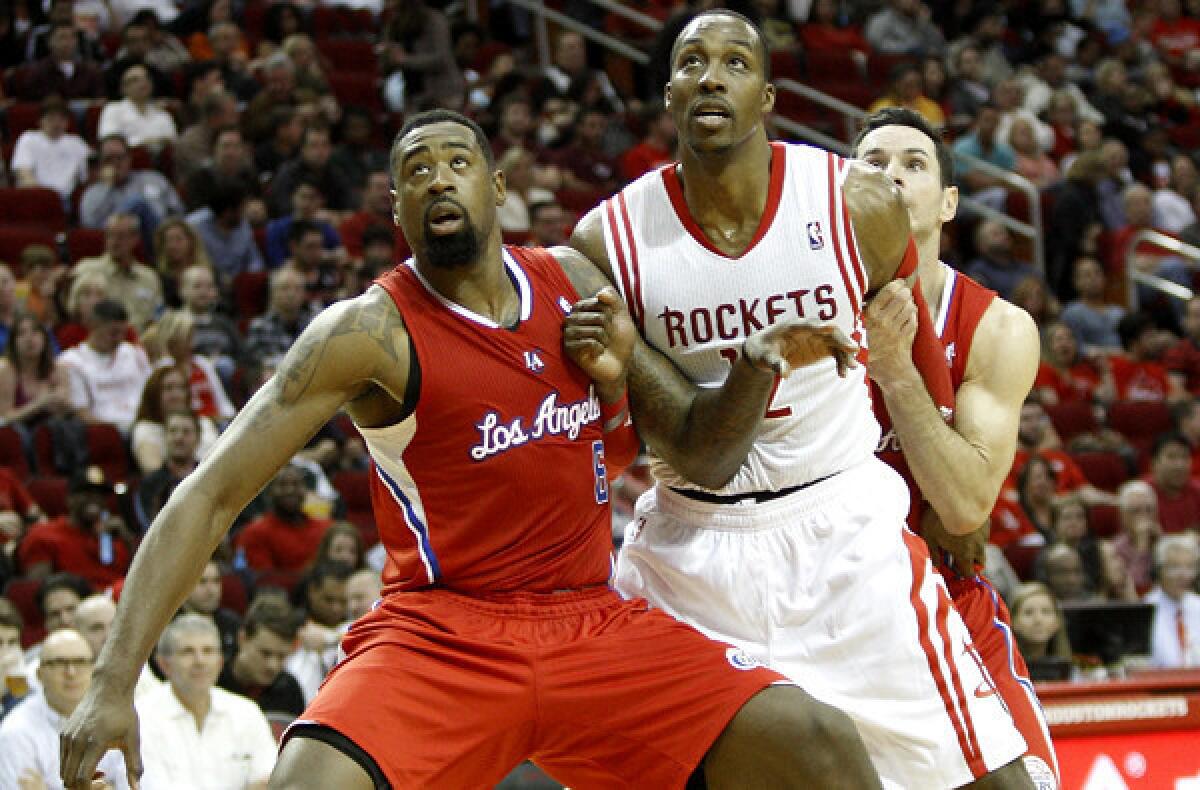 Clippers center DeAndre Jordan blocks out Rockets center Dwight Howard, with some help from teammate J.J. Redick, as they battle for rebounding position during a game Saturday night in Houston.