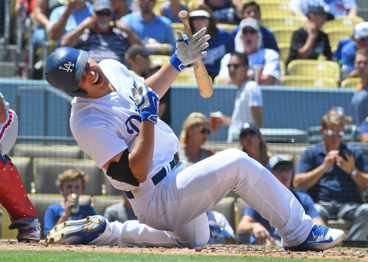 Dodgers shortstop Corey Seager goes down after being hit on the right wrist by a pitch from Philadelphia Phillies reliever Elvis Araujo in the sixth inning.
