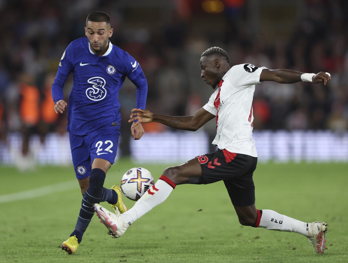 Chelsea's Hakim Ziyech, left, challenges for the ball with Southampton's Moussa Djenepo during the English Premier League soccer match between Southampton and Chelsea at St Mary's Stadium, Southampton, England, Tuesday, Aug. 30, 2022. (AP Photo/Ian Walton)