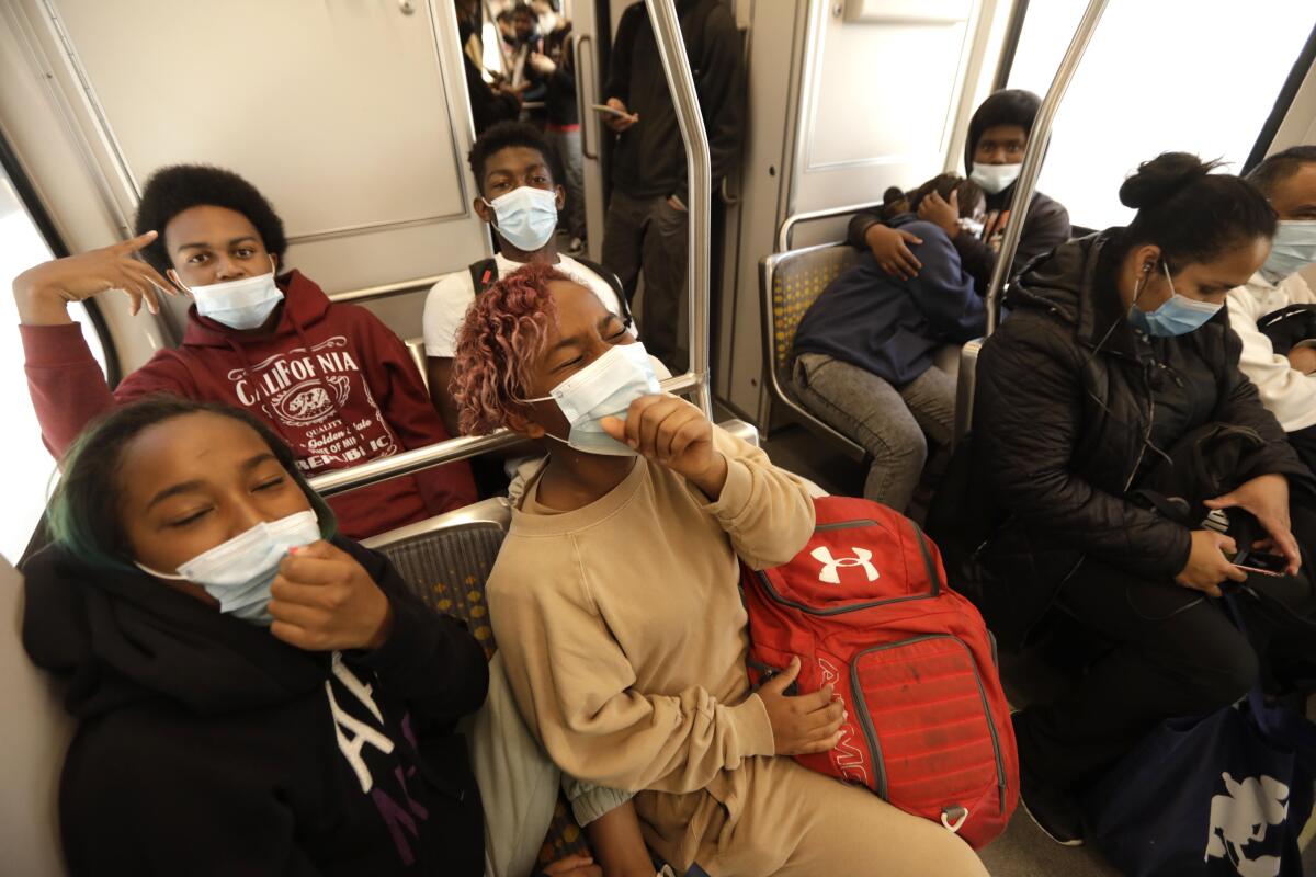 Students wearing masks in a subway car