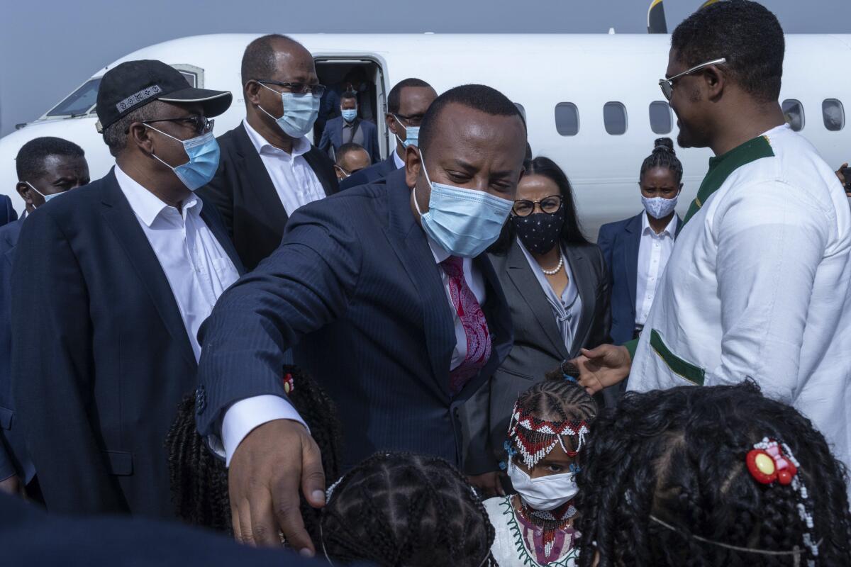Children greet Ethiopia's Prime Minister Abiy Ahmed and his entourage at an airport