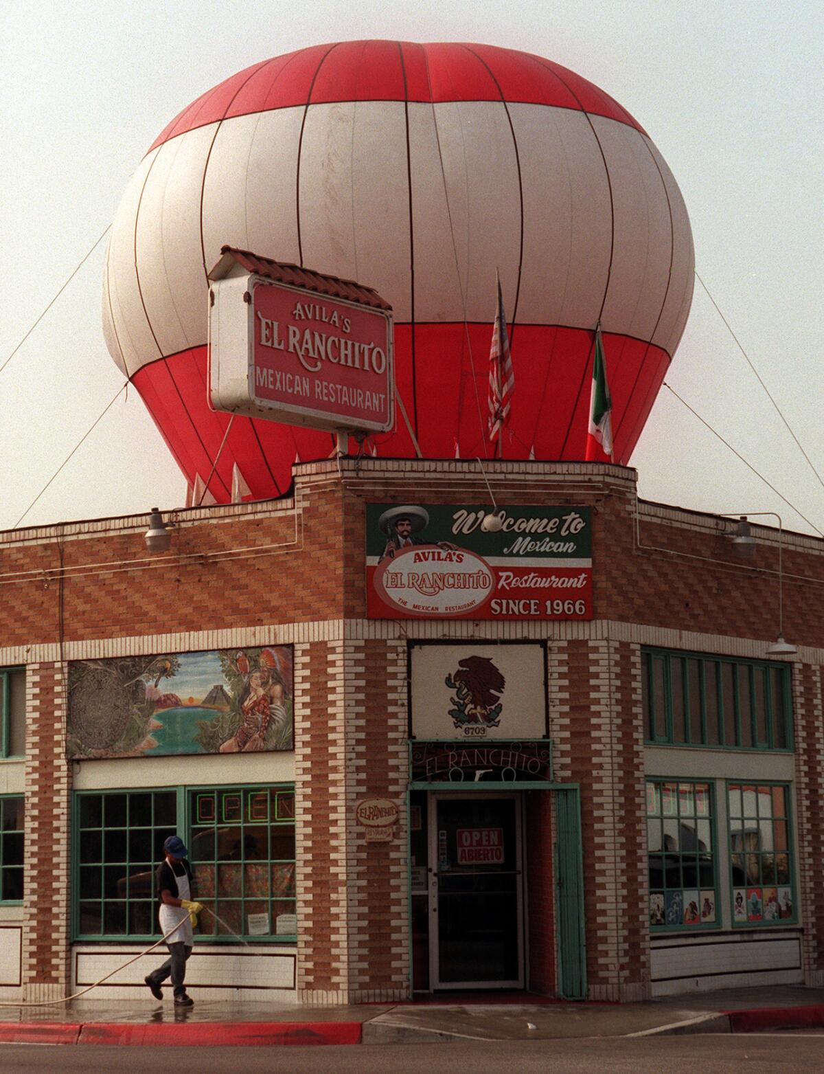 A brick corner building with a red-and-white balloon rising from it.