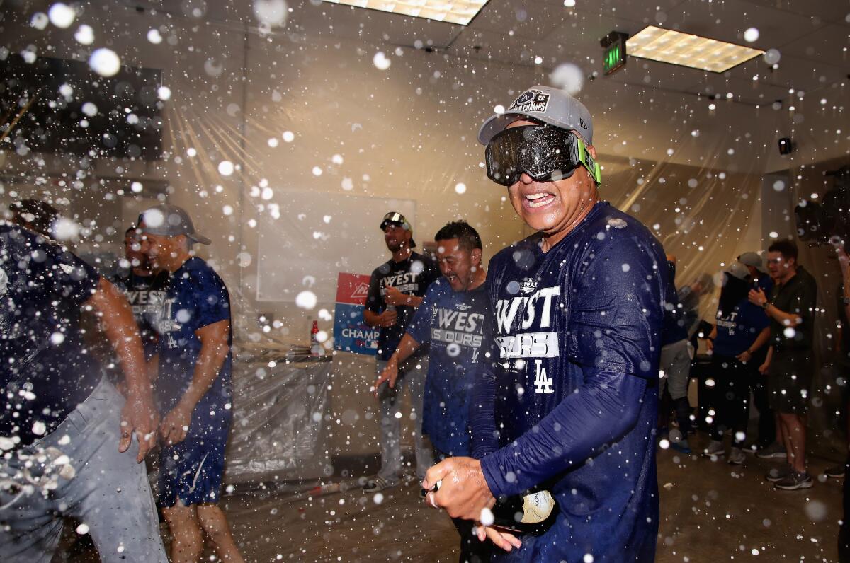 Manager Dave Roberts celebrates after the Dodgers clinched the NL West title on Sept. 13 in Phoenix.