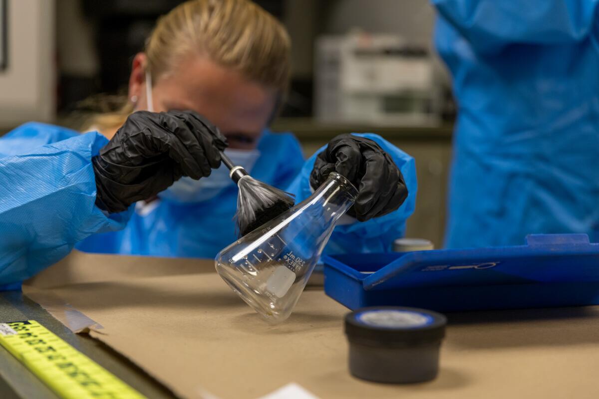 Christina Brown lifts fingerprints from a flask during a session of the Costa Mesa Citizen's Police Academy on Thursday.