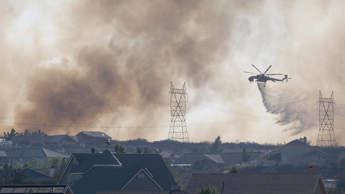 En julio, un helicóptero trabaja para apagar un fuego cerca de Oak Hills, California. En los últimos meses, los drones privados han sobrevolado peligrosamente cerca de los aviones que combaten incendios, interfiriendo con sus operaciones.