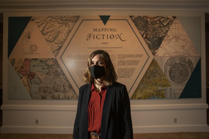 SAN MARINO, CA-JANUARY 14, 2022: Curator Karla Nielson is photographed at the entrance to the "Mapping Fiction" exhibition at the Huntington Library in San Marino. On the occasion of the centennial of James Joyce's Ulysses, "Mapping Fiction" exhibition explores the construction of fictional worlds through maps and novels. (Mel Melcon / Los Angeles Times)