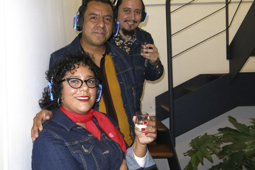 Miembros de la banda La Santa Cecilia, del frente hacia atrás, La Marisoul, Pepe Carlos y Alex Bendaña, posan para un retrato durante la presentación de su álbum "Cuatro copas", en la Ciudad de México, el 8 de noviembre de 2022. (Foto AP/Berenice Bautista)