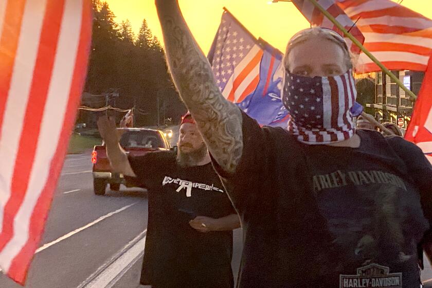 Supporters of President Donald Trump and police wave flags in Sandy, Ore.
