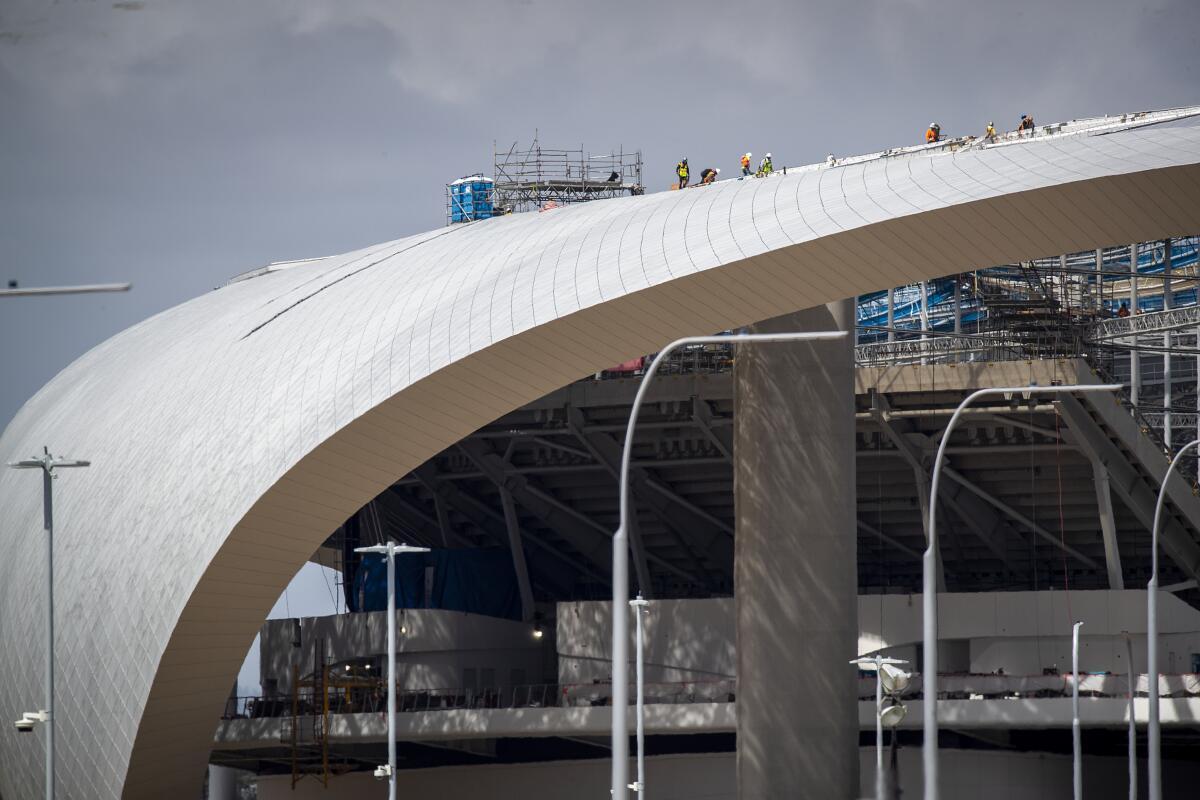 Construction workers are shown at SoFi Stadium in Inglewood on March 19, 2020.