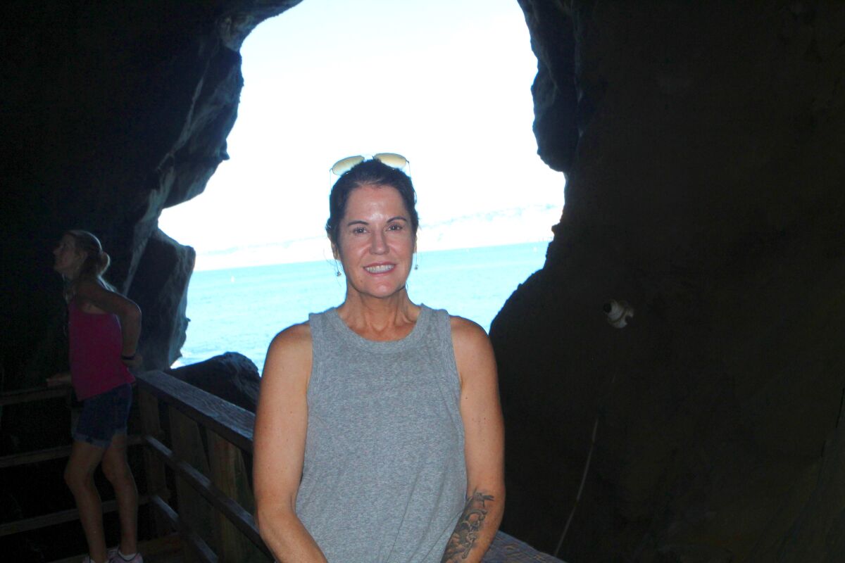 Like other businesses interviewed by the Light, Sunny Jim’s Cave Store owner Shannon Smith — shown at the mouth of her cave near Cook’s Crack — said patronage is down by about half what it should be this time of year.