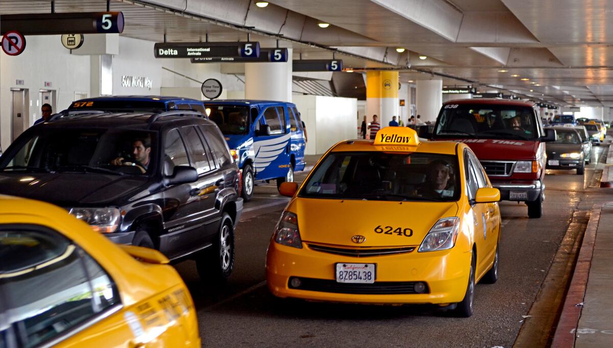 Taxi cabs and shuttles make their way through Los Angeles International Airport.