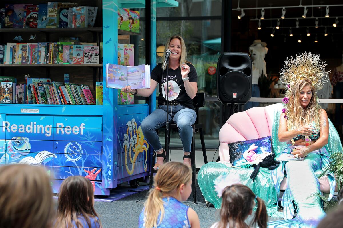 Author Kim Ann reads from one of her children's story books during Wednesday's grand opening for the Reading Reef library.