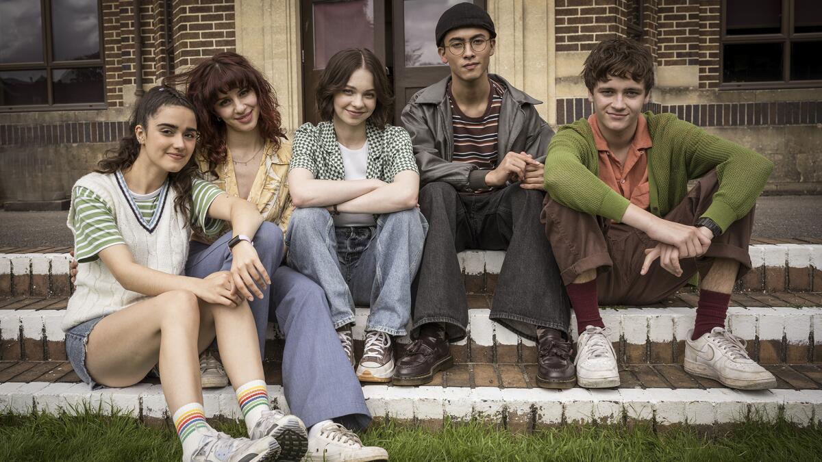 Five teenagers sitting on stairs.