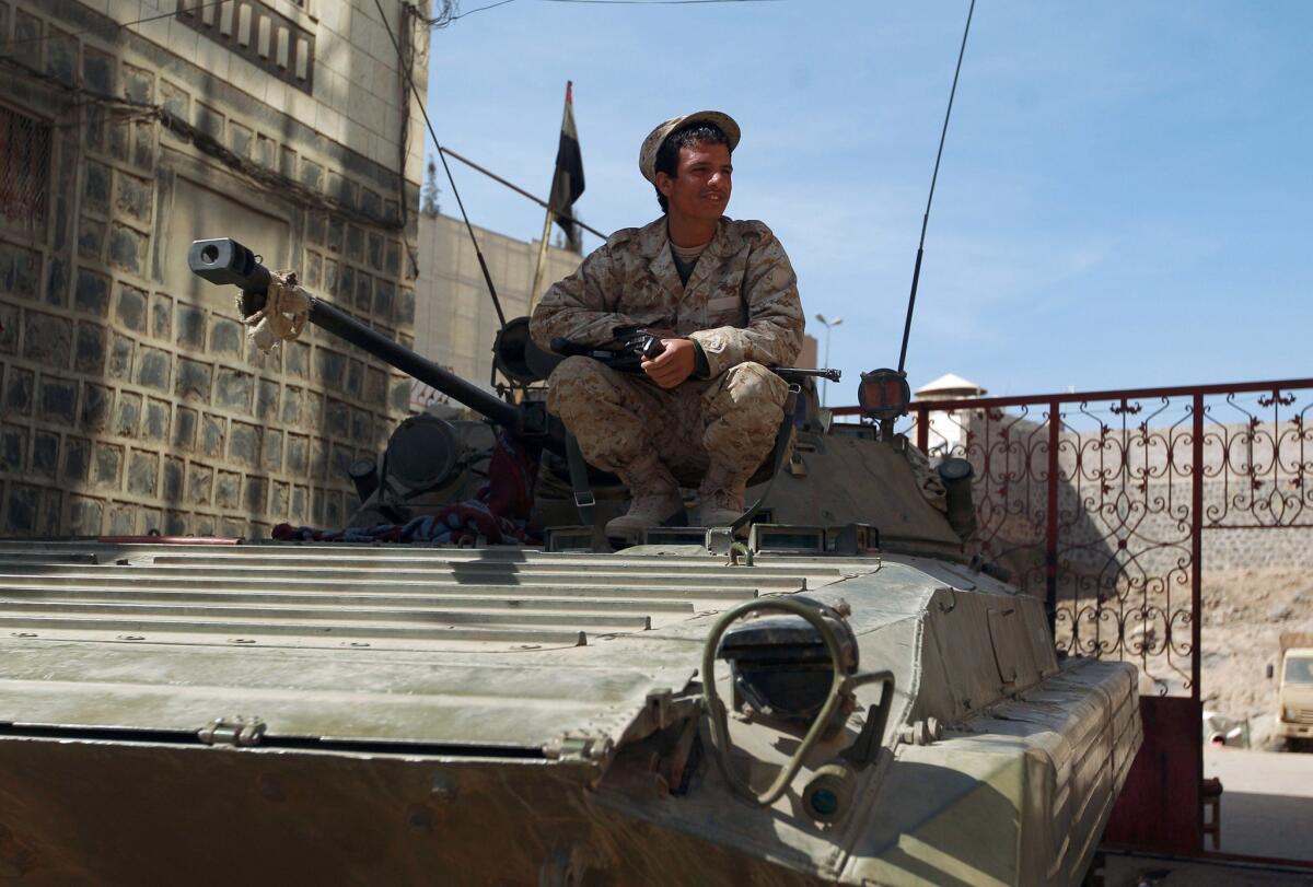 A Houthi rebel wearing a uniform confiscated from the Yemeni army sits on a government tank near the residence of President Abdu Rabu Mansour Hadi in Sana on Jan. 22.