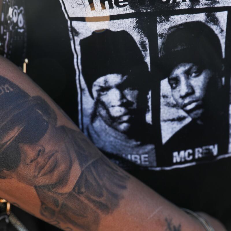A woman shows her Eazy-E tattoo and N.W.A T-shirt