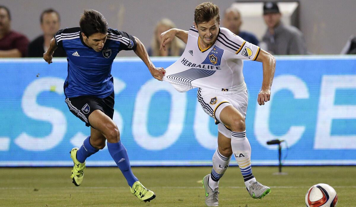 San Jose Earthquakes's Shea Salinas, left, pulls the jersey of Los Angeles Galaxy's Robbie Rogers during the second half of an MLS soccer match on July 17.