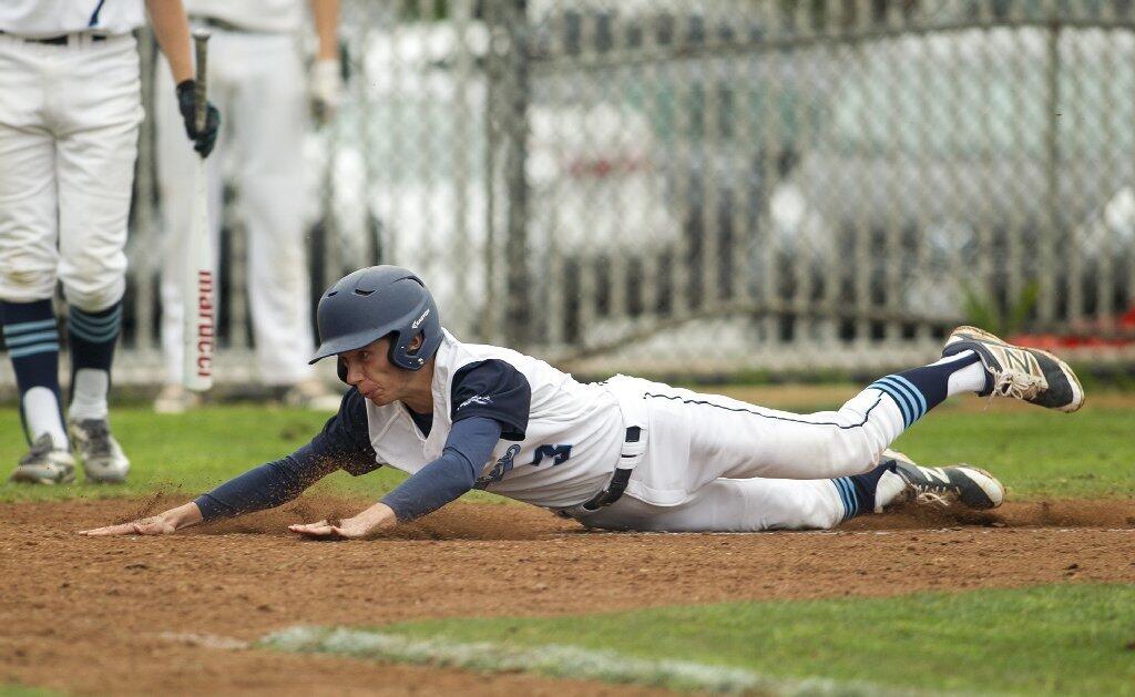 Corona del Mar's Lucas Ciachurski dives into home plate in the fifth inning during a Pacific Coast League game against Woodbridge on Tuesday.