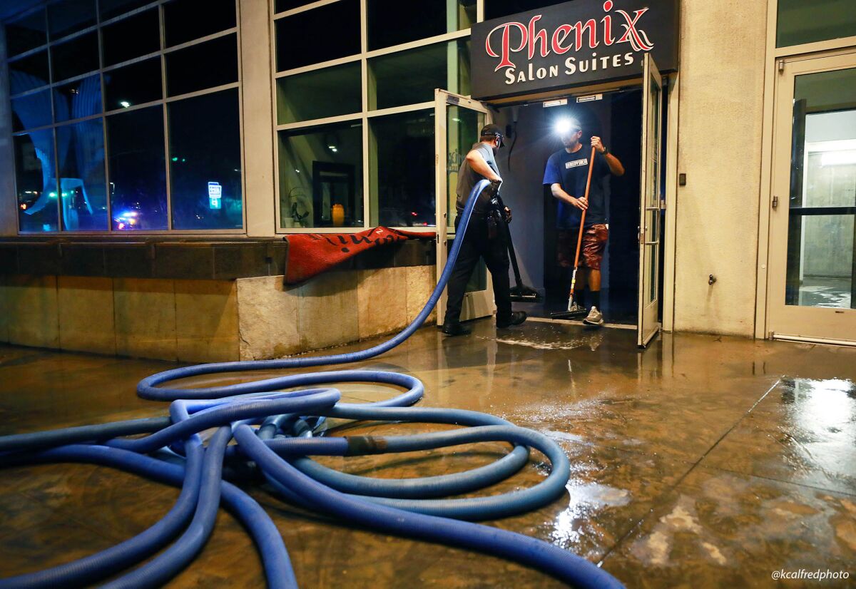 Workers cleaned up the Phenix Salon Suites after a broken water main sent water into downtown streets Sunday.