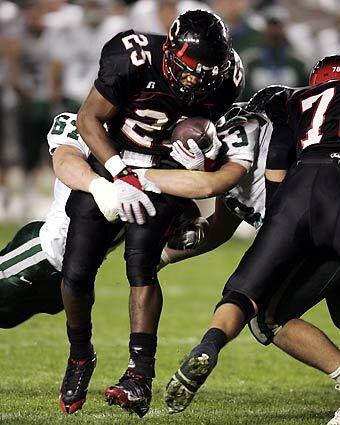 Centennial running back Arthur Burns is brought down by the De La Salle defense during the first quarter Friday night at the Home Depot Center.