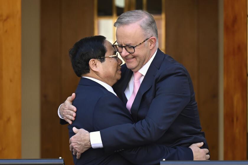 Australian Prime Minister Anthony Albanese, right, and Vietnamese Prime Minister Pham Minh Chinh embrace at the end of a joint statement at Parliament House in Canberra, Thursday, March 7, 2024. The Australian and Vietnamese prime ministers have discussed ways of improving an already booming economic relationship. (Lukas Coch/AAP Image via AP)