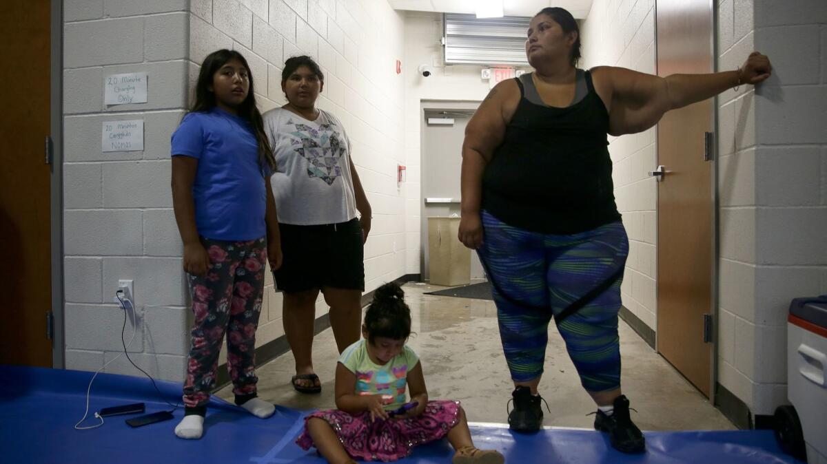 Natalie Hernandez, 33, with three of her nine children at the Red Cross evacuation shelter at St. Joseph High School in Victoria, Texas.