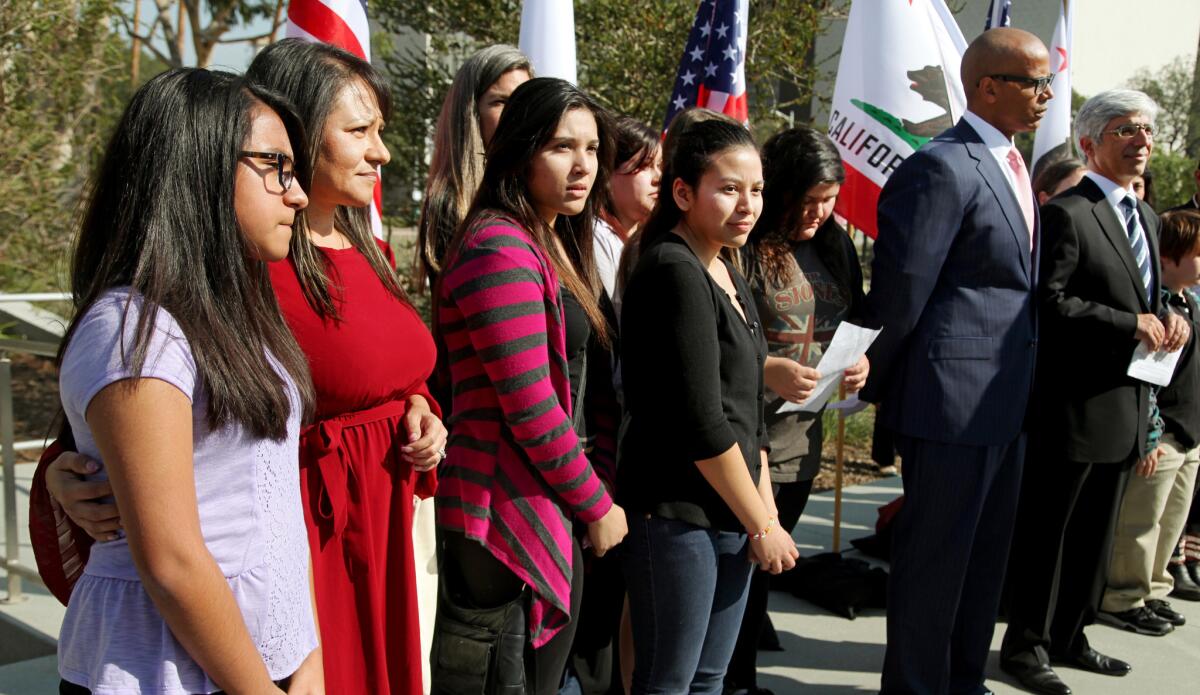 Attorneys Theodore Boutrous, far right, and Marcellus McRae, second from right, take questions from the media, as they are joined by nine California public school students who are suing the state to abolish its laws on teacher tenure, seniority and other protections, during a news conference outside the Los Angeles Superior court on Jan. 27.