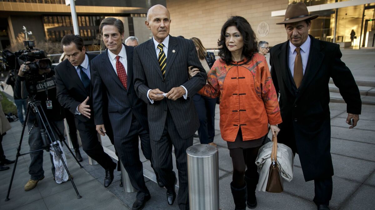 Former Los Angeles County Sheriff Lee Baca, center, with his wife, Carol, right, and his attorney, Nathan Hochman, center left, leaves court after a mistrial was declared in his obstruction trial.