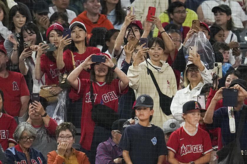 Los Angeles Angels fans take photos of Shohei Ohtani, bottom center.