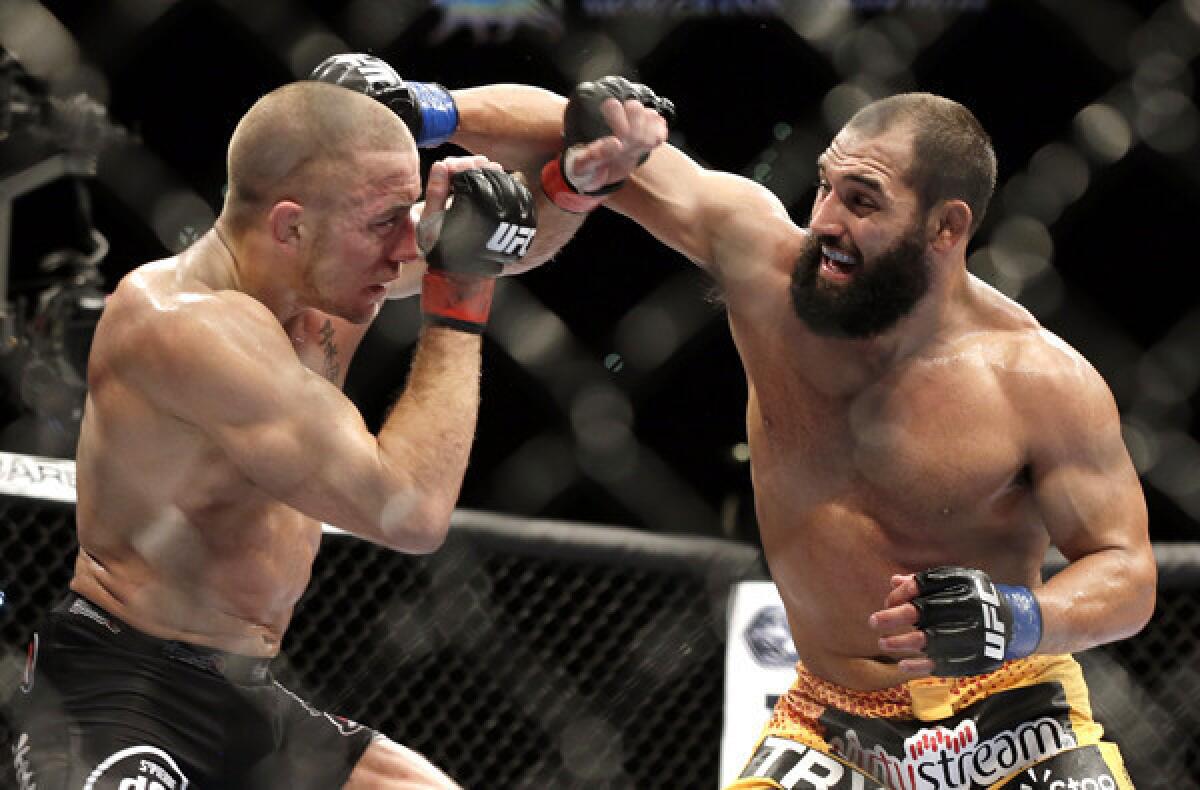 Georges St-Pierre, left, and Johny Hendricks exchange punches during their welterweight title fight at UFC 167 in November 2013.