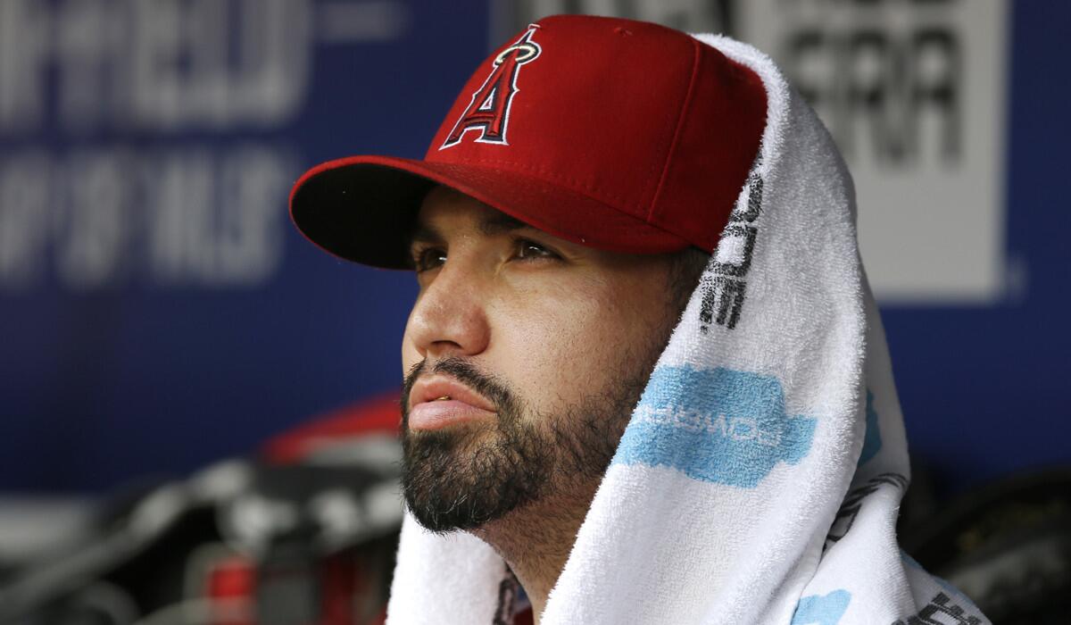 Angels starting pitcher Hector Santiago sits in the dugout during the second inning against the Texas Rangers on Wednesday.